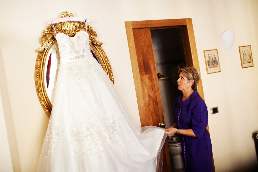 mother of the bride looking at her daughter's beautiful wedding dress