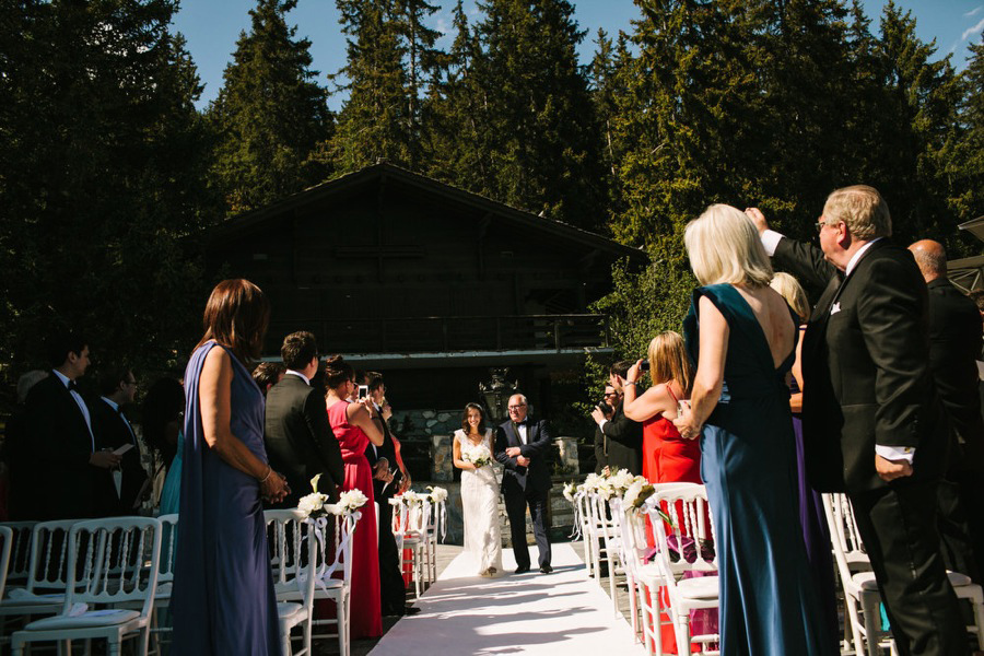 bride and her father walking down the isle for the wedding at LeCrans Hotel in Crans-Montana