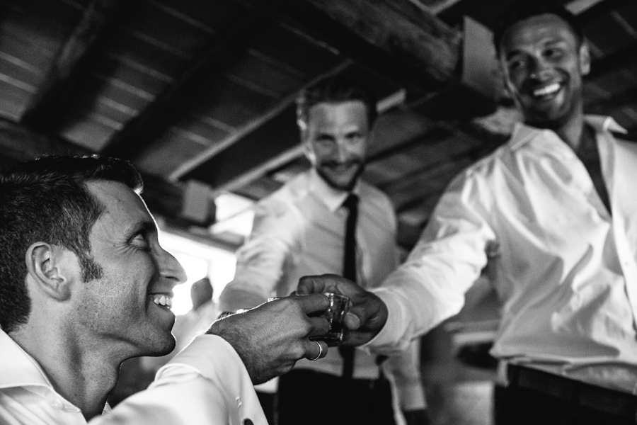 Groom having a drink with friends before wedding in Tuscany