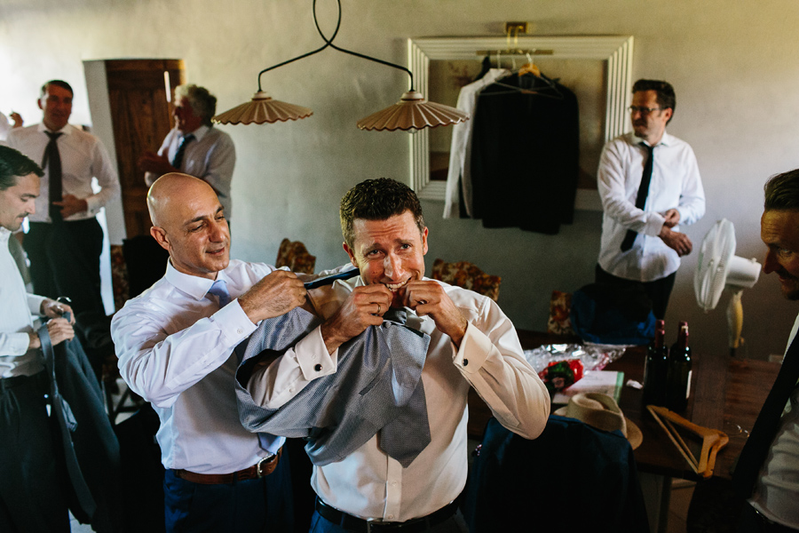 Groom putting on his suite before wedding