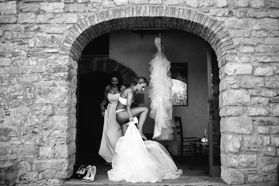 Naked bride putting on her dress For Her wedding in Tuscany