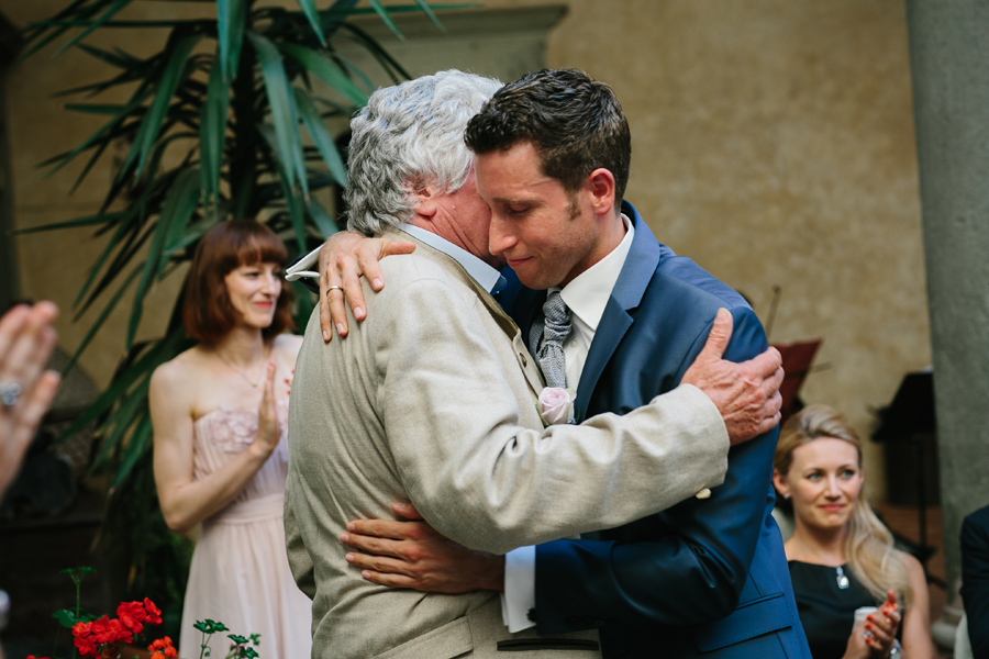 Groom hugging his father during ceremony
