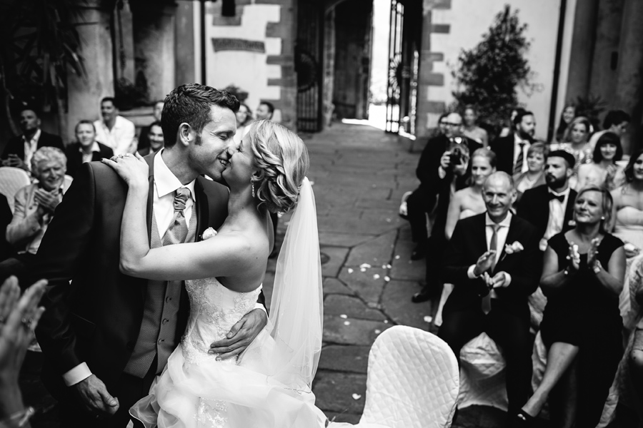 Bride and groom kissing during wedding ceremony at castello del