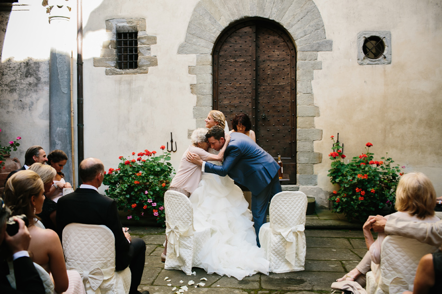 Groom hugging his grandmother during wedding ceremony in tuscany