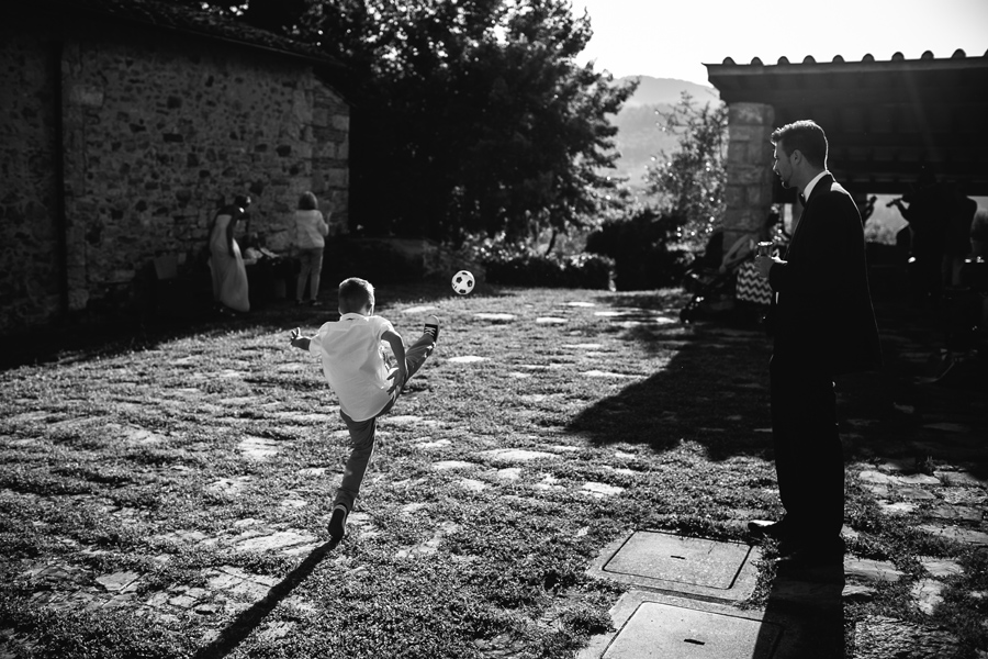 Little boy playing with the ball at the wedding in tuscany