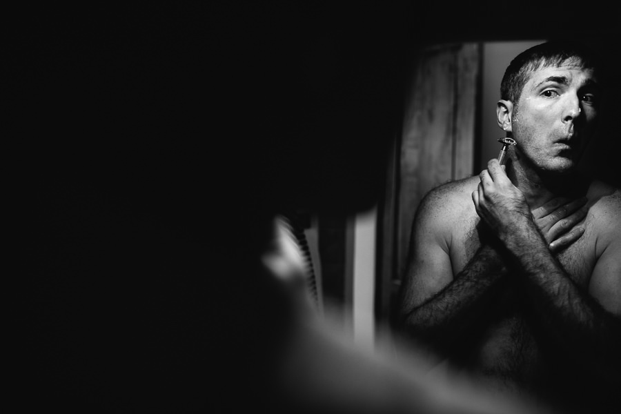 Groom shaving before wedding at castello di meleto