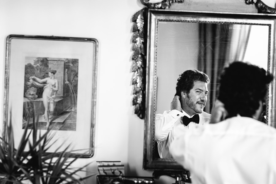 groom getting ready in front of mirrir