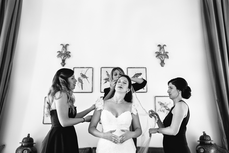 bride and best friends putting veil on