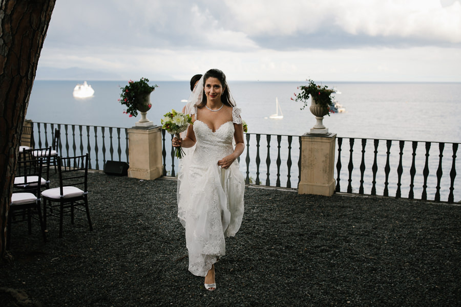 bride walking with sea in the background