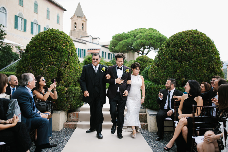 groom walking down the aisle with his parents at la cervara