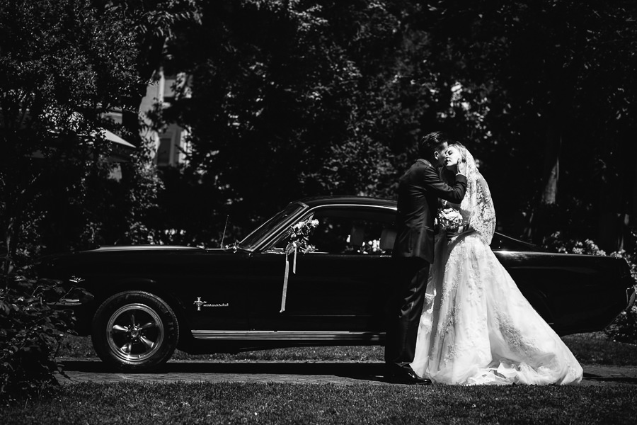 bride and groom with an old mustang car