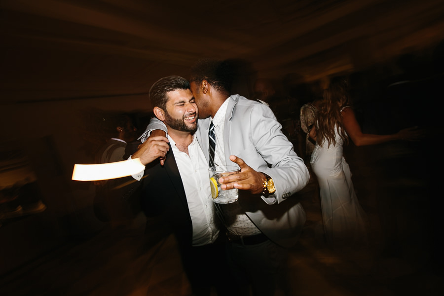 groom hugging guest during party