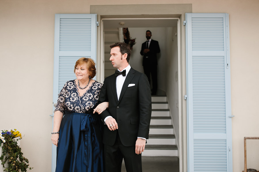 groom and his mom walking down the aisle on lake como