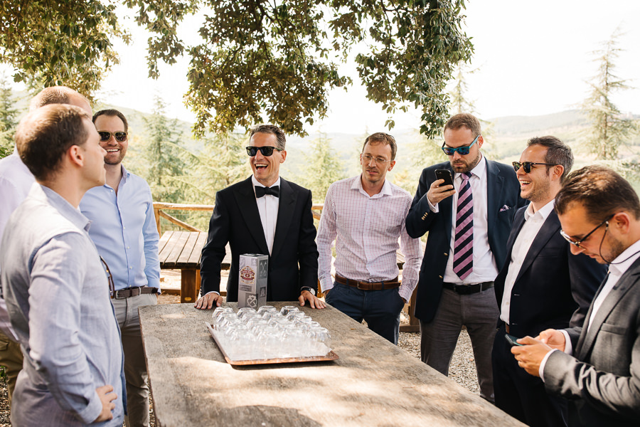 Groom and groomsmen having a drink before wedding
