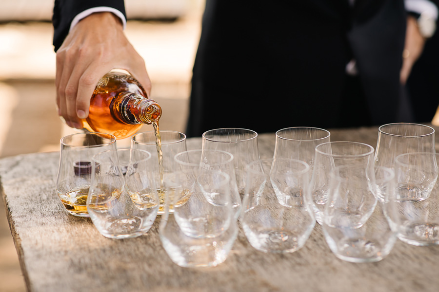 Groom and groomsmen having a drink before wedding